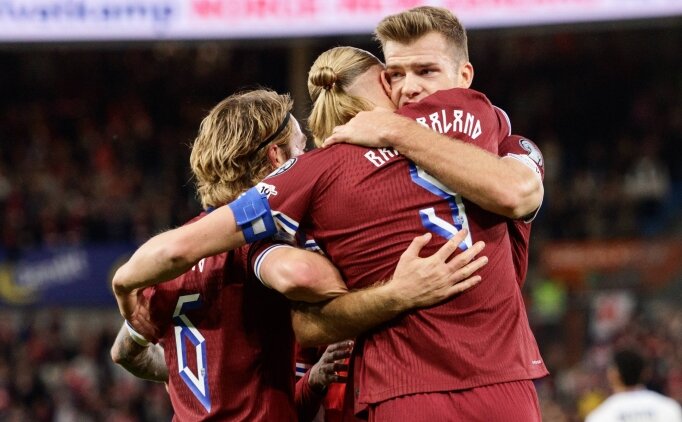 норвежские футболисты радуются победе, обнимаясь на поле